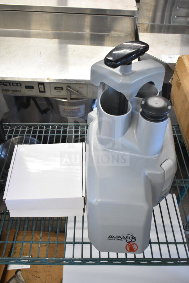 Brand new AvaMix Revolution 928CFEED continuous feed attachment, minor scratches, shown with original box, model markings visible.
