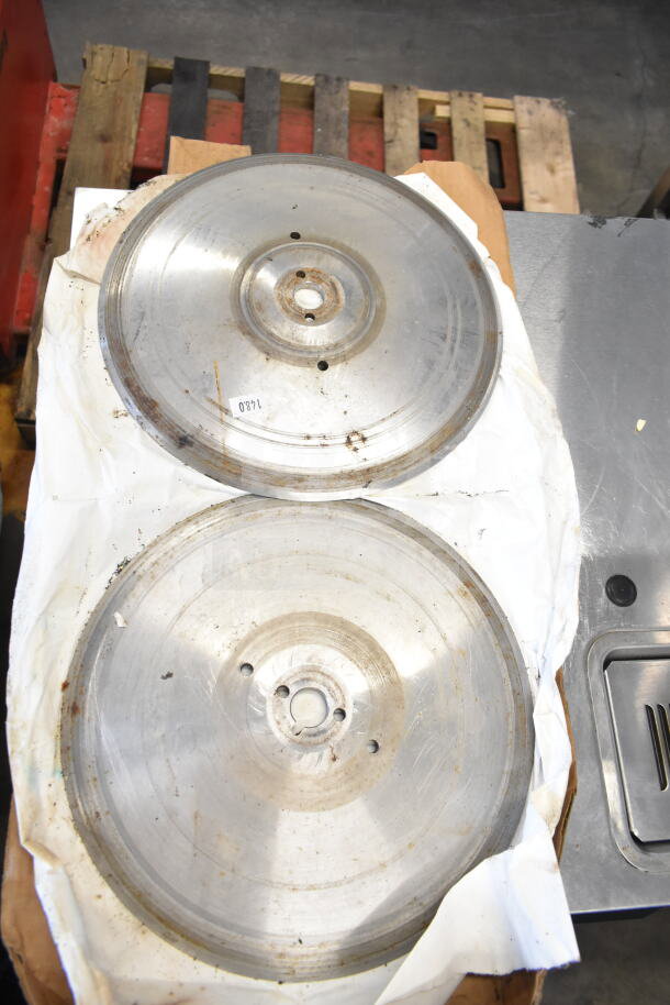 Two metal meat slicer blades, circular design, moderate wear, shown on packaging paper, marked with number 1480.