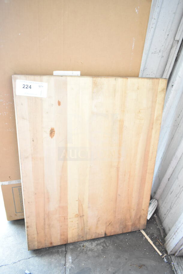 Butcher block wooden cutting board, rectangular, light wood with visible grain, minor wear, tag number 224 displayed.