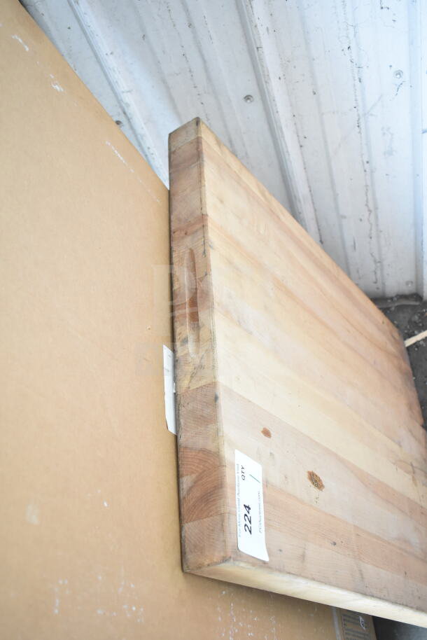 Butcher block wooden cutting board with visible grain pattern and minor wear. Auction tag labeled "224".