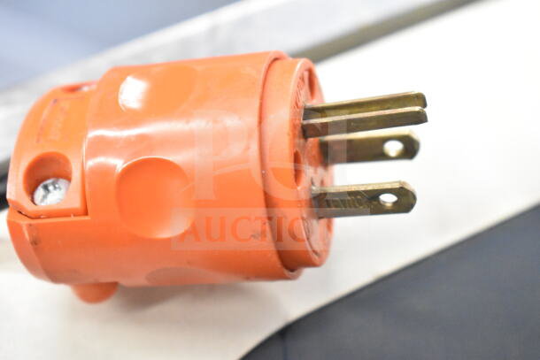 Orange electrical plug connector close-up with three brass prongs, brand "Leviton" visible.