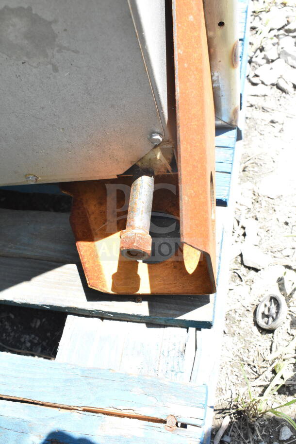 Rusty side view of Hobart Commercial Roll In Rack Oven on a wooden pallet. Visible bolts and metal base element.
