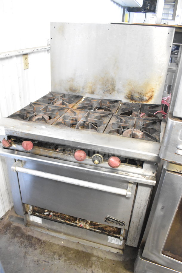 Therma-tek TMDR-6-1N 6-burner gas range with oven and backsplash; visible wear; sturdy commercial-grade unit.