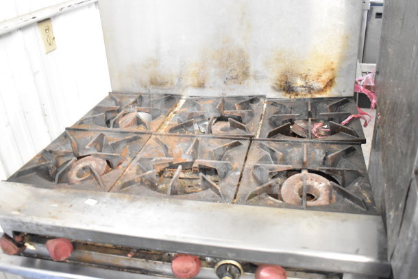 Therma-tek TMDR-6-1N 6 burner range with oven and backsplash, showing notable wear. Natural gas-powered commercial unit.