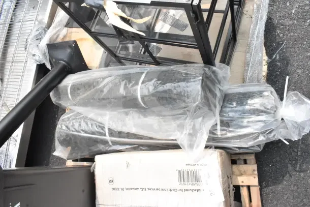 10 brand new scratch and dent items, including anti-fatigue mats and a sink, wrapped in packaging and visible on pallets.
