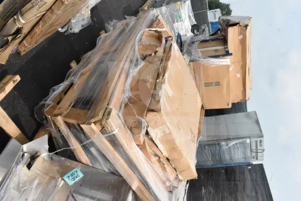 4 new scratch and dent items, including shelving posts and work table undershelf, wrapped on pallets. Labels show "SKID 3 OF 2."
