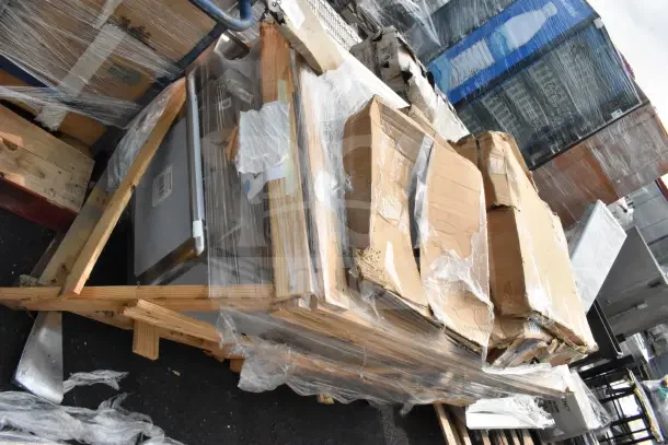 Brand new scratch and dent shelving posts and work table under shelf, wrapped in packaging on a pallet.