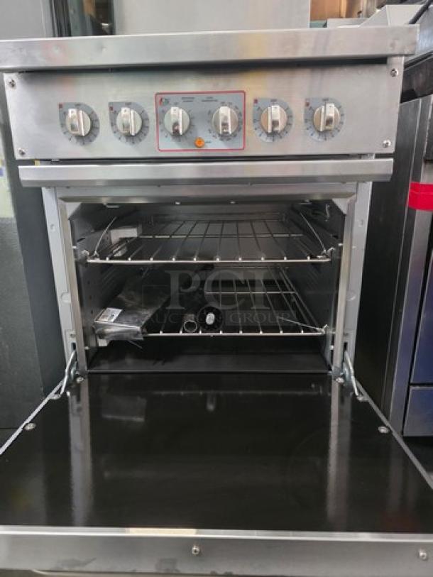 24" CPG 4-burner electric range with space saver oven, 208V, 3 PH. Bottom cover bent.