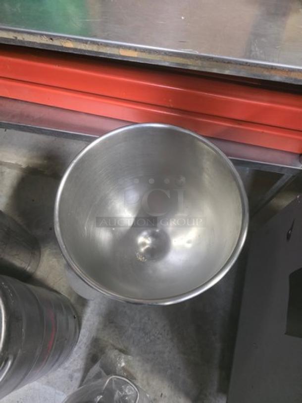 Stainless steel mixing bowl with smooth interior. Accompanied by a compatible rolling cart. Visible clean condition.