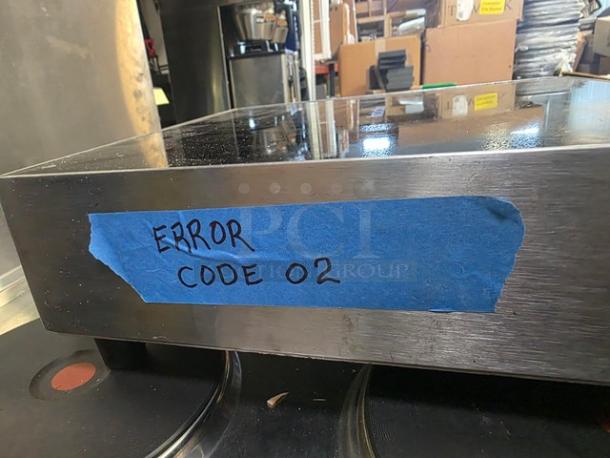 Cooktek MC1500 induction cooktop, single burner, countertop model. Displays "ERROR CODE 02." Stainless steel finish.