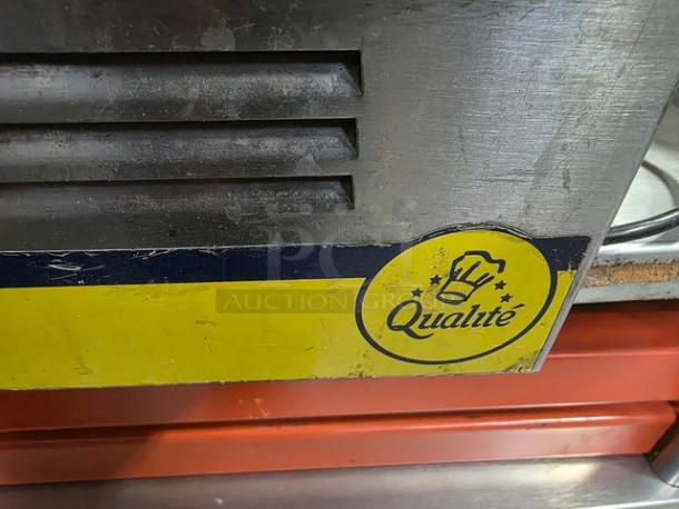 Qualite full-size electric countertop food warmer, stainless steel with visible wear. Features logo and vent details.
