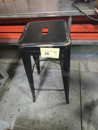 Lot of 6 black metal bar stools, stackable design, distressed finish, cut-out handle on seat. Auction tag indicates quantity: 6.