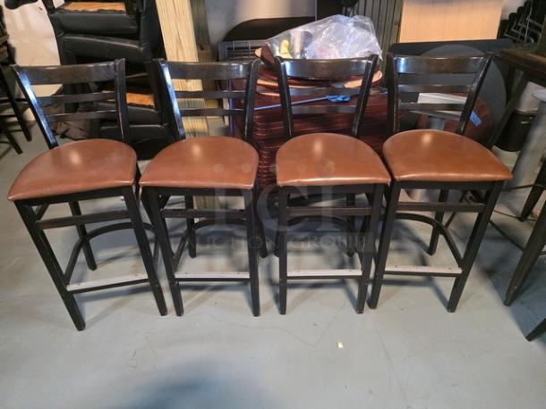 Set of four bar stools with dark wooden frames and brown cushioned seats. Good condition, sleek modern design.