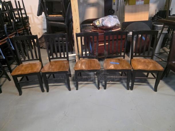 Lot of 5 wooden dining chairs with black frames and brown seats. Light wear visible. Ladder-back design.