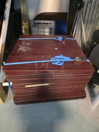 Lot of 4 wooden table tops, 36x36 inches each, no bases included. Visible wear and secured with blue straps.
