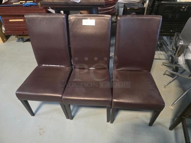 Lot of 3 brown dining chairs with cushioned seats and backs. Some visible wear on upholstery. Label with "3XBID" on one chair.