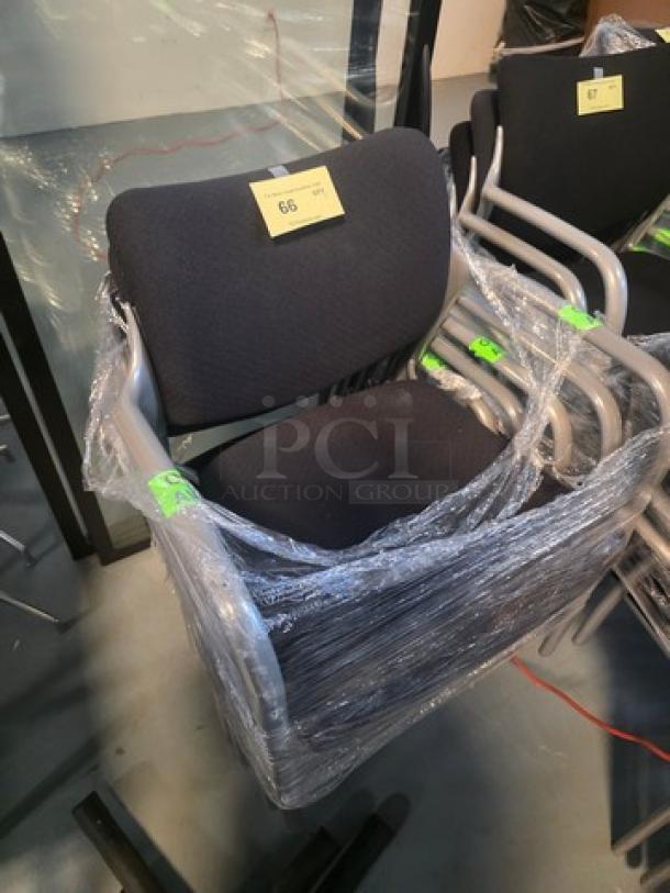 Lot of 5 stacking chairs with black fabric seating and gray powder-coated frames, wrapped for protection.