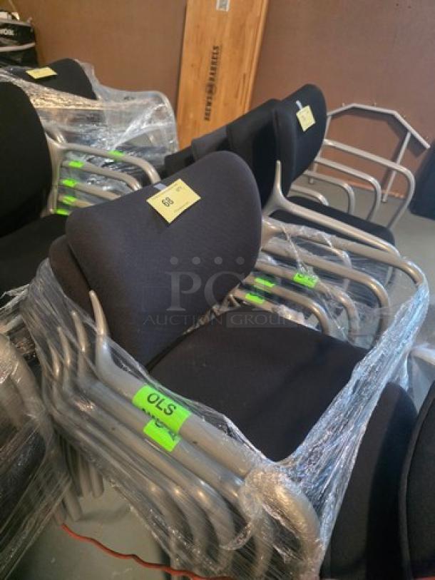 Lot of 5 stacking chairs with black fabric seats and gray powder-coated frames, wrapped in protective plastic.