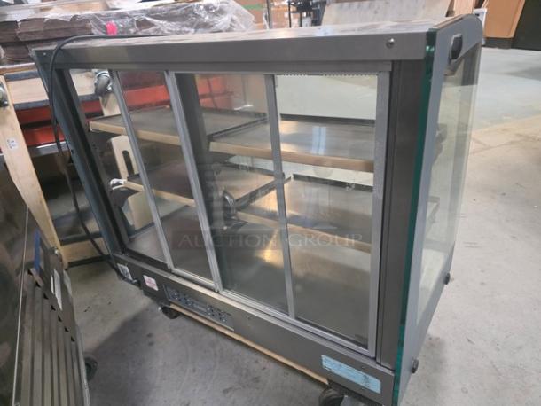 Vendo HFD000006 35" Hot Food Display Case, glass and metal design, shelves intact, on wheels, used condition.