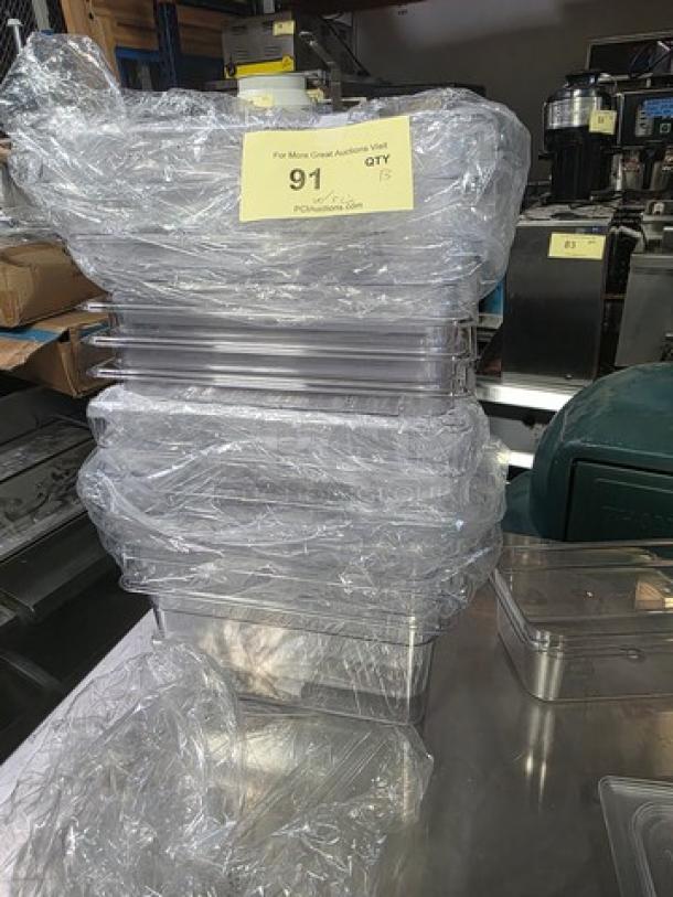 Lot of 13 Cambro plastic food pans, 5 with lids. Clean and stacked. Auction tag visible, reading "QTY 13."