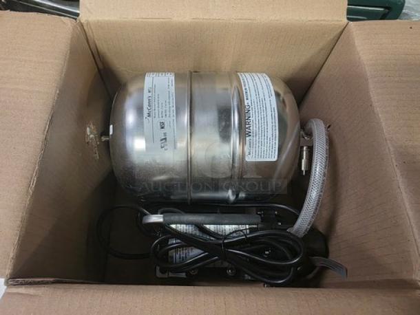 McCann's MTJ Water Booster System, stainless steel, new condition, visible labels with specifications in open cardboard box.