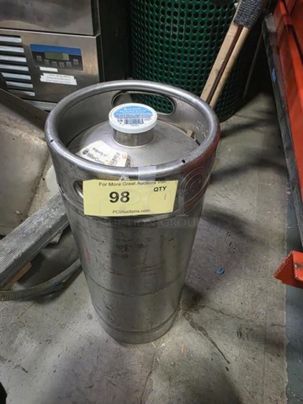 Stainless steel keg with label indicating auction item 98. Used condition with visible markings and cap seal intact.