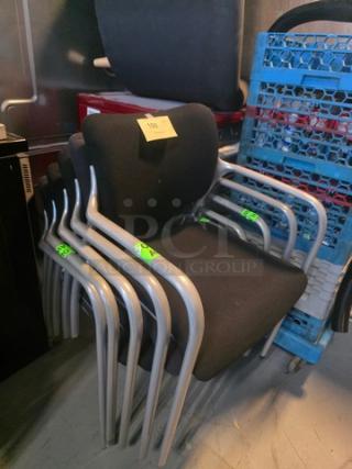 Lot of 5 stacking chairs with black fabric seats and gray powder-coated frames. Excellent condition. Tags visible.