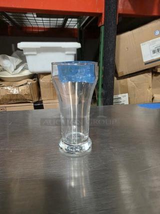 Libbey 8 oz pilsner glass, clear design, on a metal surface. Boxes visible in background.