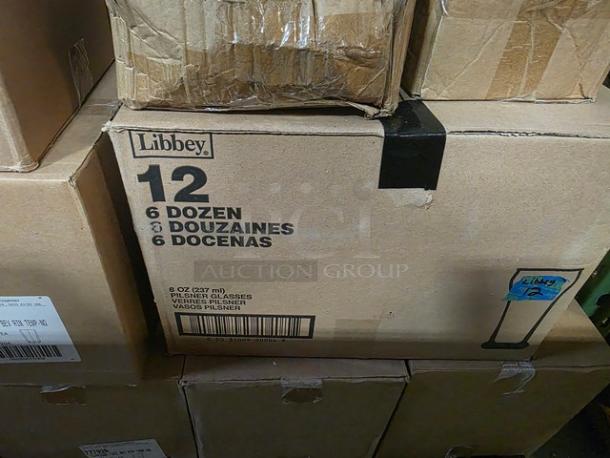 Boxes of Libbey 8 oz Pilsner glasses, 6 dozen each. Packaging shows brand name and quantity. Condition appears intact.