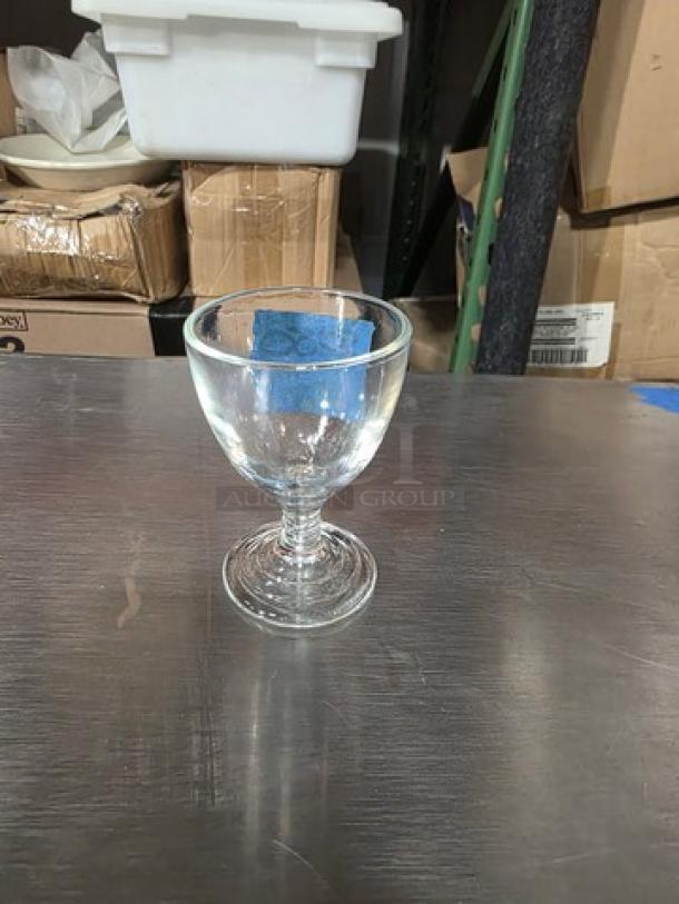 Anchor Hocking Manhattan clear ribbed cordial glass on a table, showcasing its elegant design and smooth finish.