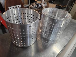Lot of 2 Winco aluminum steamer baskets, one wrapped in plastic, featuring perforated sides, in excellent condition.