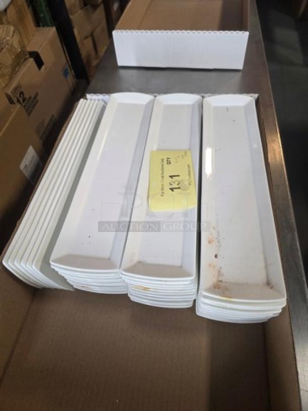 Lot of 40 Fortessa Fortaluxe rectangle platters, white porcelain, some platters with visible marks, stacked in a box.