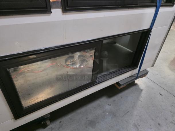 Marc Refrigeration 94" self-contained butcher meat display, used condition, with glass front and metal interior shelving.