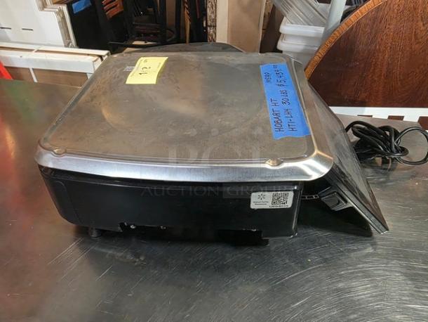 Hobart HT Series HTI-LH4 30 lb. price computing scale with metal top, visible power cord, and labeled with model information.