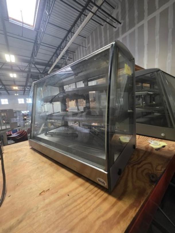 Sanden Vendo Hot Food Display Case, Model HFD000006. 115V, 1PH. Clear glass with stainless steel frame, in a warehouse setting.