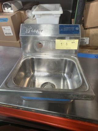 Stainless steel commercial wall-mount hand sink, used condition, visible brand label, features flat basin design.