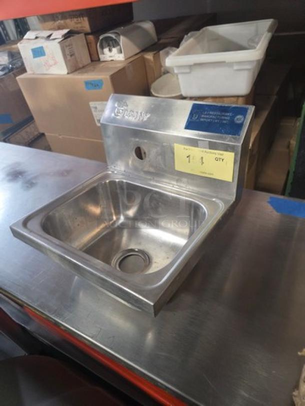 Stainless steel commercial wall-mount hand sink with backsplash, slightly used, includes pre-drilled faucet holes and drain.