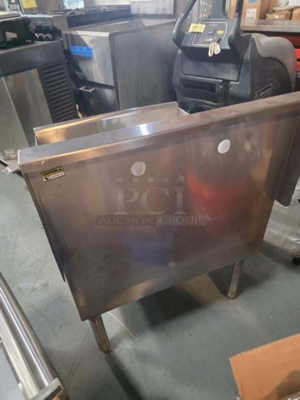 Commercial stainless steel utility sink, featuring a deep basin and sturdy legs. Signs of moderate use; perfect for restaurant kitchens.