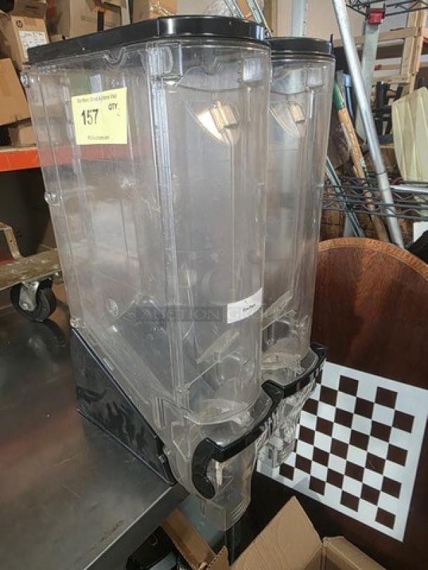 Lot of two 5-gallon gravity bin food dispensers in clear plastic, with black lids and levers. Lightly used condition.
