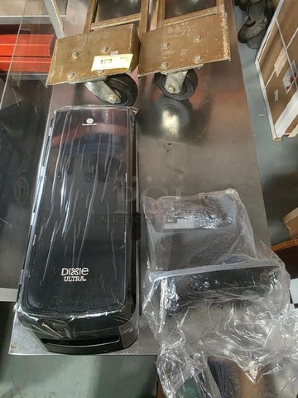 Dixie Ultra Dispenser, black, in good condition, with mounting hardware included. Efficient paper towel dispensing solution.