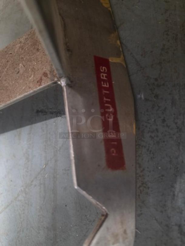 Wall mountable pot rack with metal construction, visible wear. Features sections for organization, labeled "Pie Cutters."