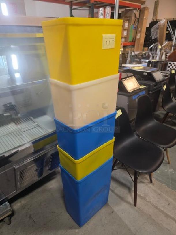 Lot of 5 plastic storage bins in various colors, stacked vertically. Used condition, slight scuff marks visible.