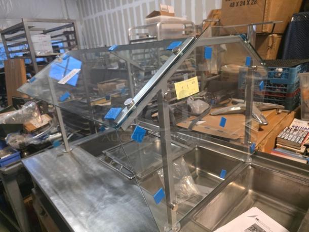Glass sneeze guard for steam table, in good condition, with metal frame and mounting hardware. Steam table not included.
