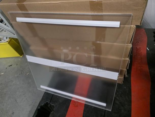 Box of three 24"x24" acrylic sheets, clear and glossy, stacked with protective film. Suitable for versatility in projects.