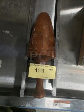 Wooden masher, dark finish, ergonomic handle, moderate wear, auction tag labeled "188", displayed on metal surface.