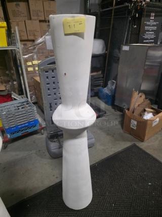 Tall white decorative floor vase with a unique hourglass shape. Appears in good condition. Yellow tag with a number visible on top.