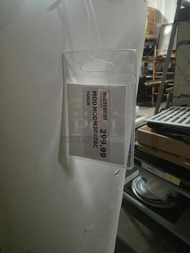 Decorative floor vase, modern design, white finish, slight surface marks, price tag reads $299.99, labeled "MODM030826."