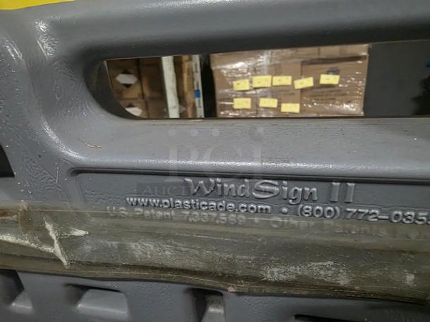 Plasticade Wind Sign II Quick-Change Frame, gray, visible branding and website, textured surface, used condition.