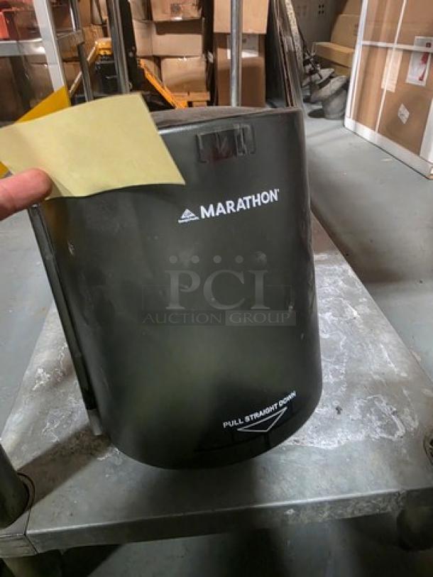 Marathon paper towel dispenser, wall-mounted, black finish, good condition, visible logo and instructions for use.