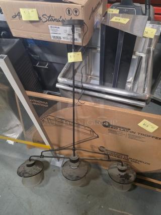 3-Light Linear Pendant Chandelier, featuring metal shades, in fair condition. Includes visible wiring and packaging materials.